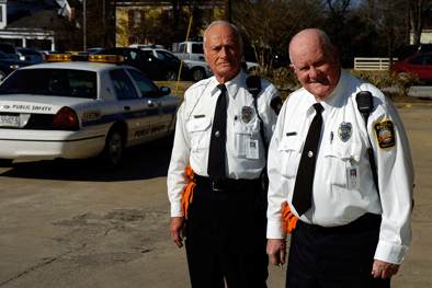 Sentinels George and Leo in uniform next to police vehicle