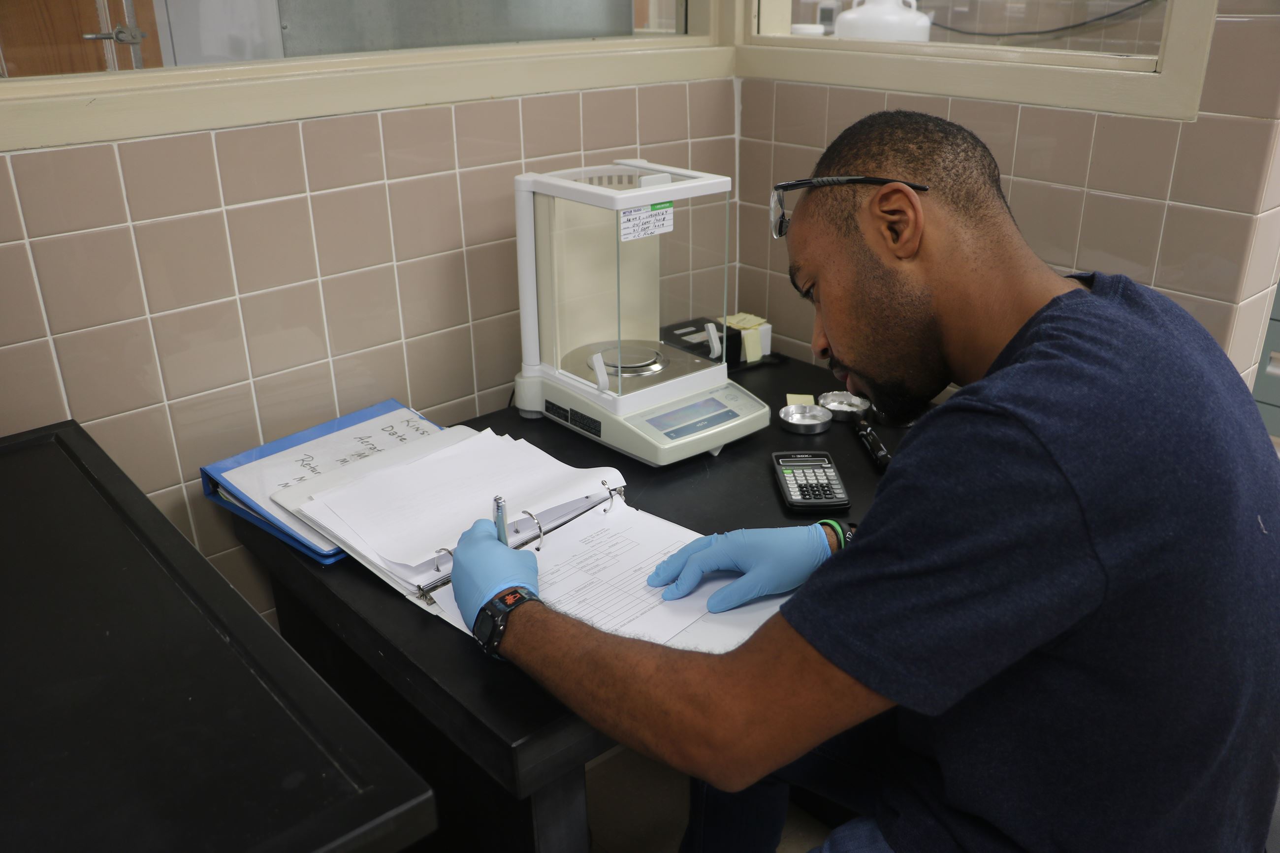 An intern records data in the lab
