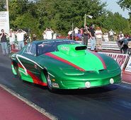 A green car on a drag racing strip.