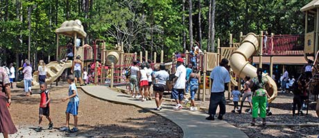 A playground with a large amount of kids playing on it.